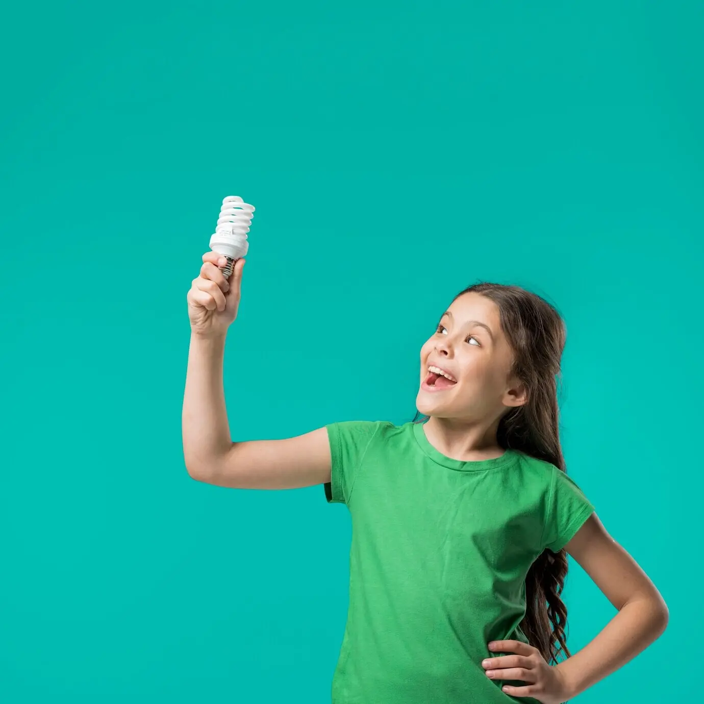 Ein süßes Mädchen steht mit einer Lampe in einem Studio.